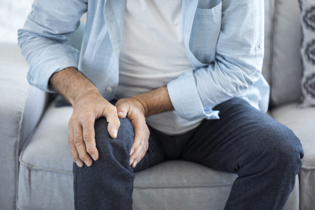 Older man experiencing knee pain from possible arthritis. Older man experiencing knee pain from possible arthritis.